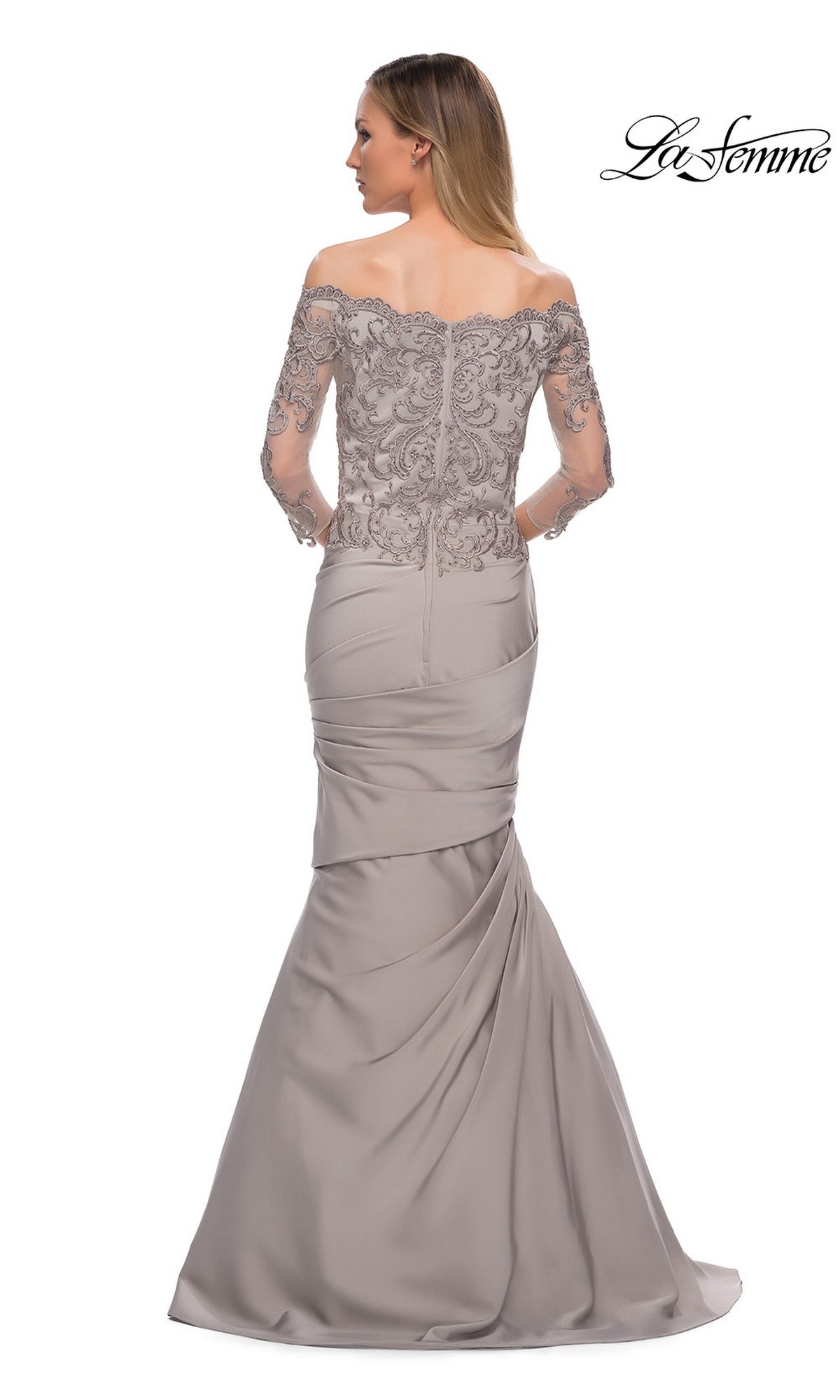 Woman in a Long Formal Dress: La Femme 29324, off-the-shoulder, long-sleeve silver gown with beaded lace bodice and fit-and-flare skirt; “La Femme” logo top right.